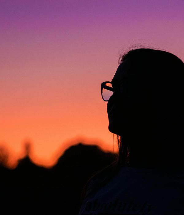 Person meditating peacefully with a purple glow in the background.